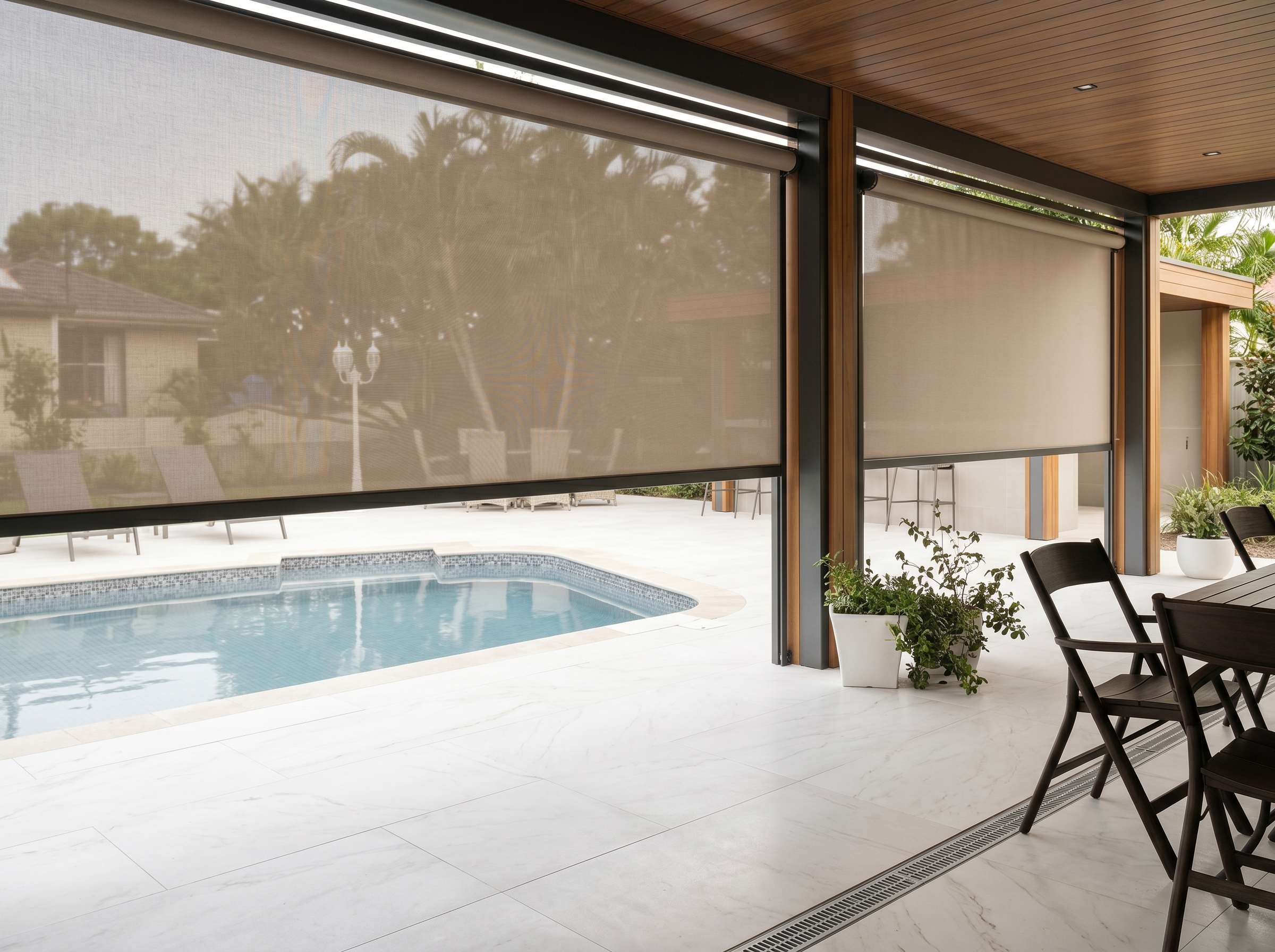 Covered patio featuring custom shades that provide solar protection and privacy while overlooking a backyard pool and outdoor seating area.
